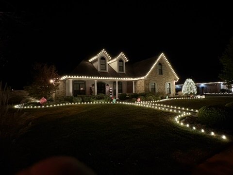 Dormered stone home with curved pathway lighting