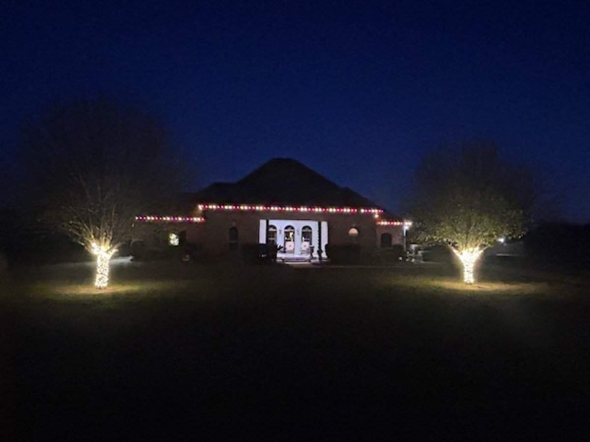 Dormered home with lit tree and pathway