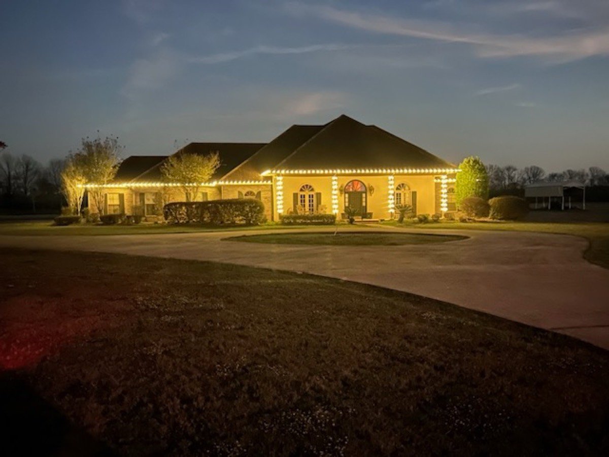 Stucco home with roofline lighting at dusk